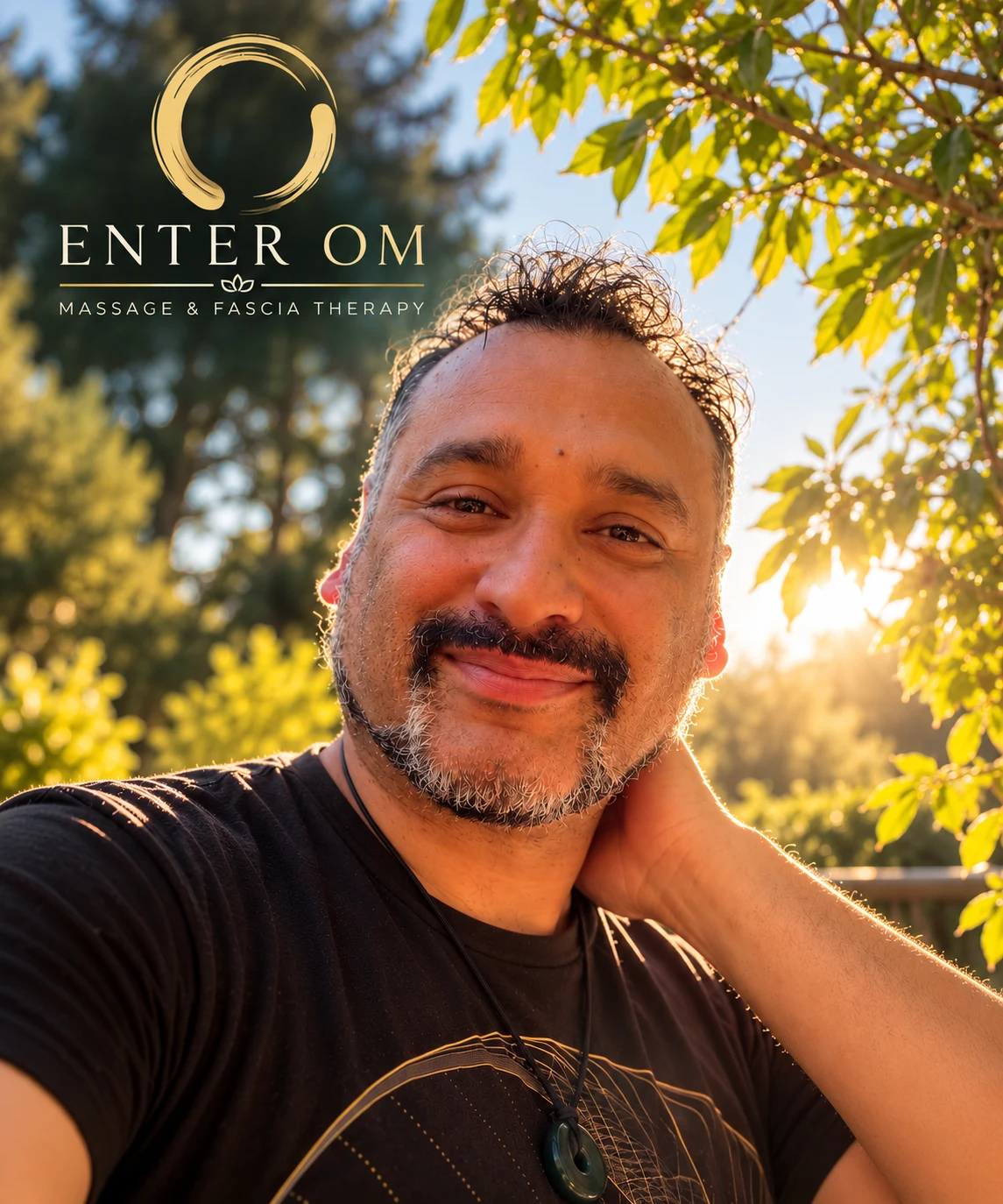 Carlos outdoors in warm sunlight, with Enter Om branding